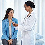 A woman speaks with her healthcare provider during a checkup.