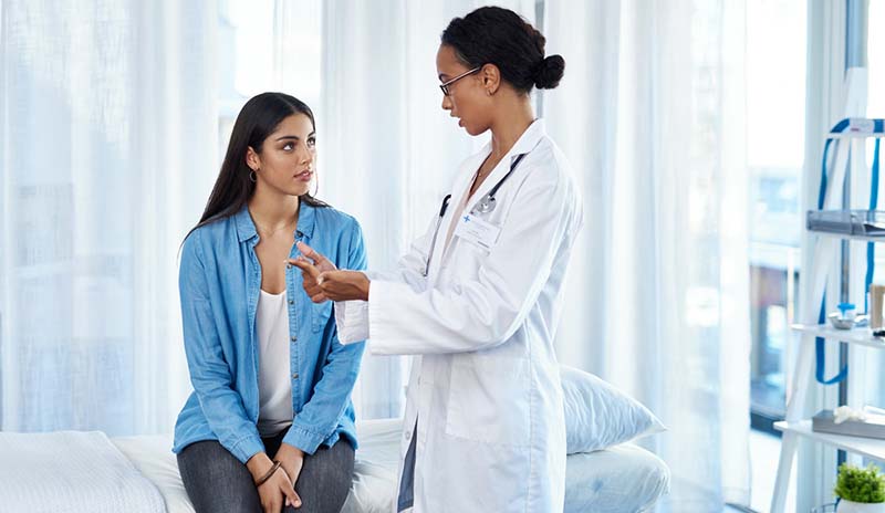 A woman speaks with her healthcare provider during a checkup.