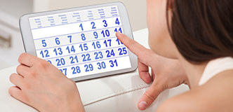 Woman pointing to a calendar on a tablet device.