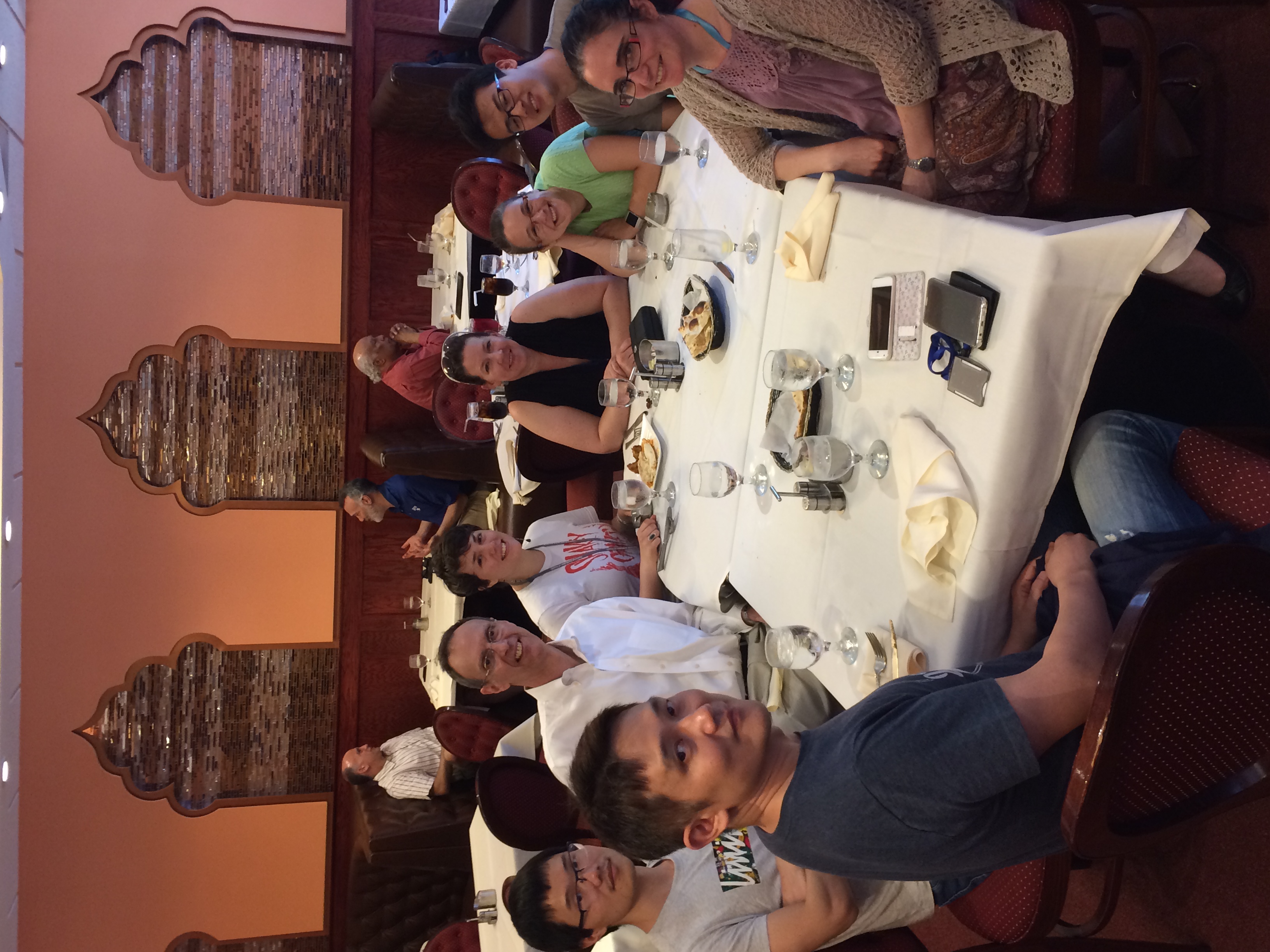 Eight lab members are seated around two tables at a restaurant.