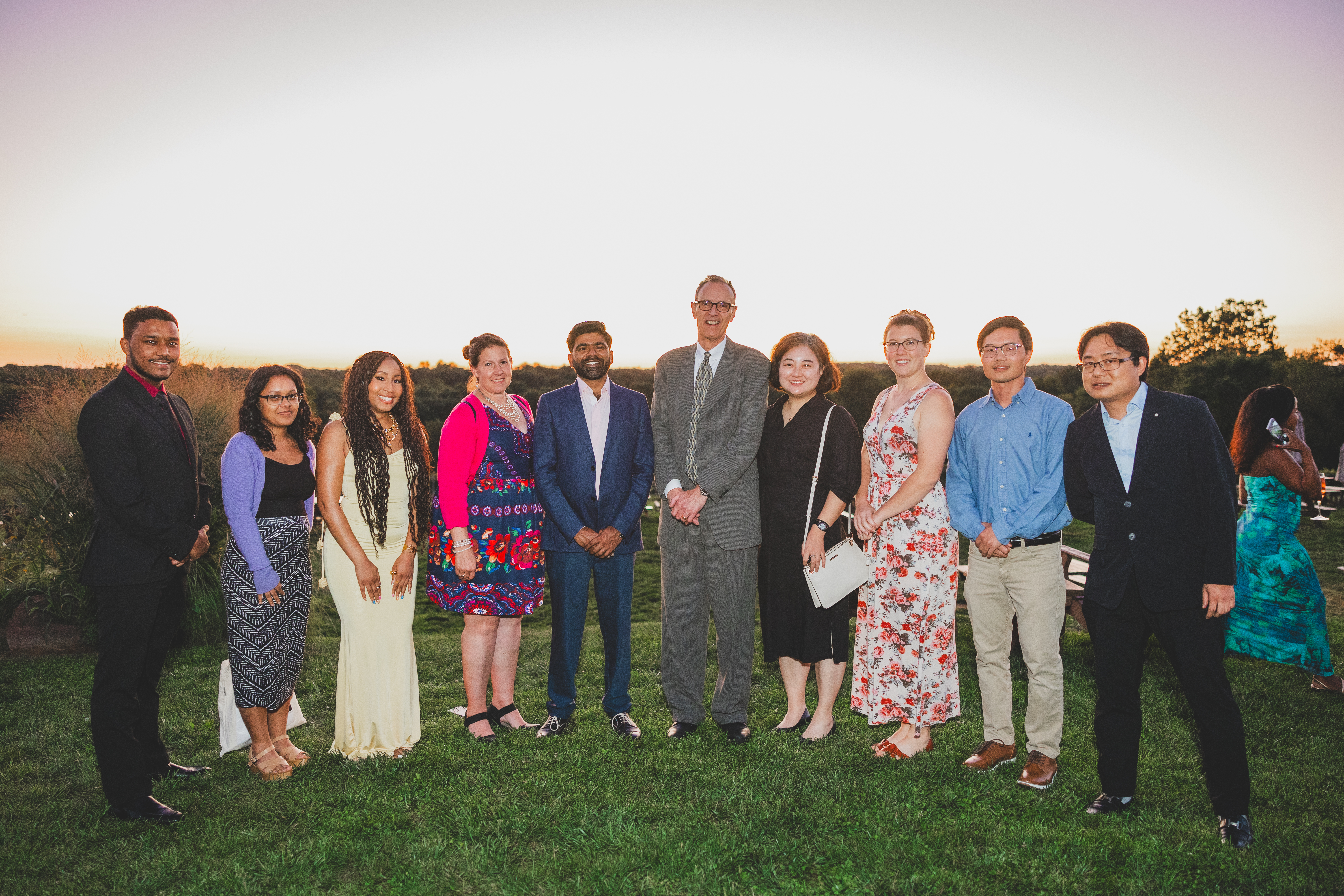 Lab members posing together outside at a wedding in 2024. 