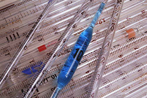 Several syringe ampoules including one filled with a blue liquid.