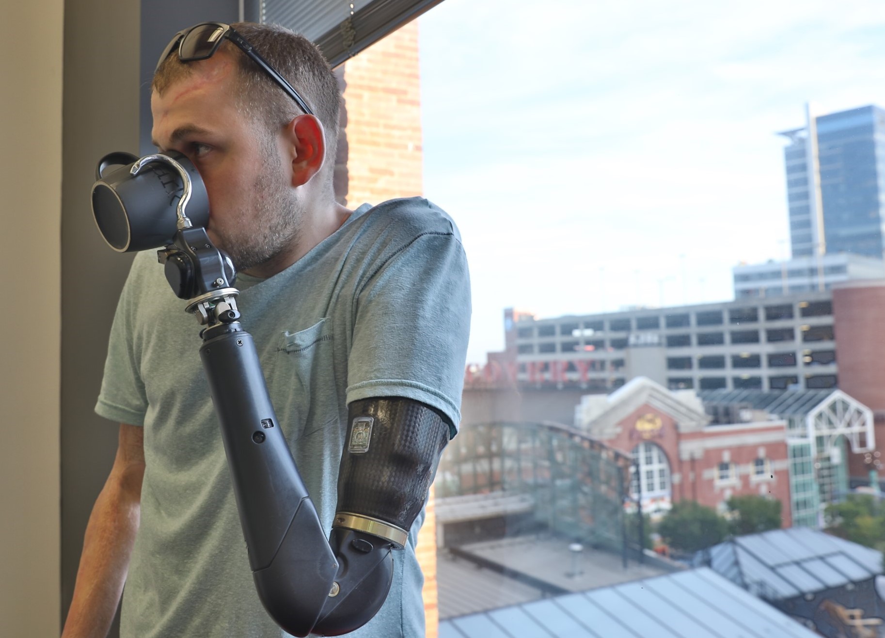 Gyorgy Levay holding cup with prosthetic arm.