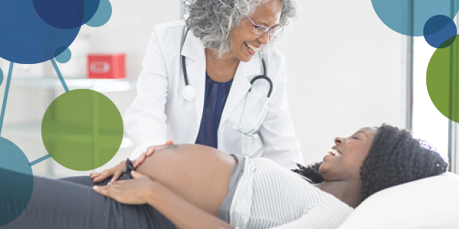 A healthcare provider and pregnant person smiling during a prenatal exam.