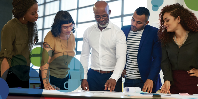 A group of employees looking at a document together in an office.