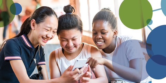 Three teenage girls looking at a cell phone.