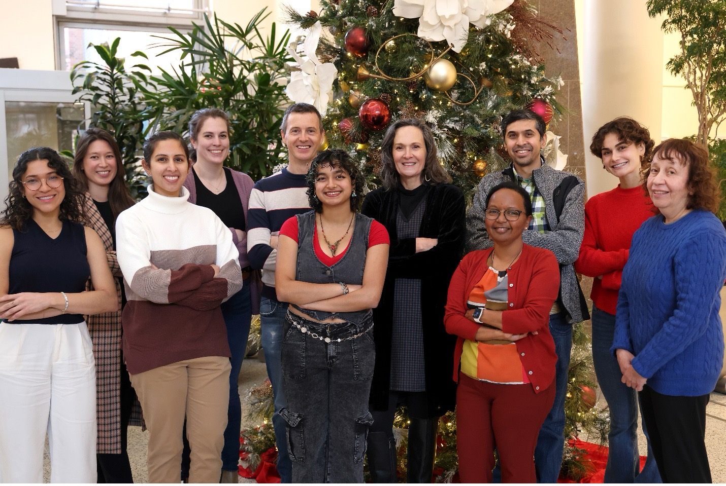 Photo of lab personnel standing in front of holiday decorations