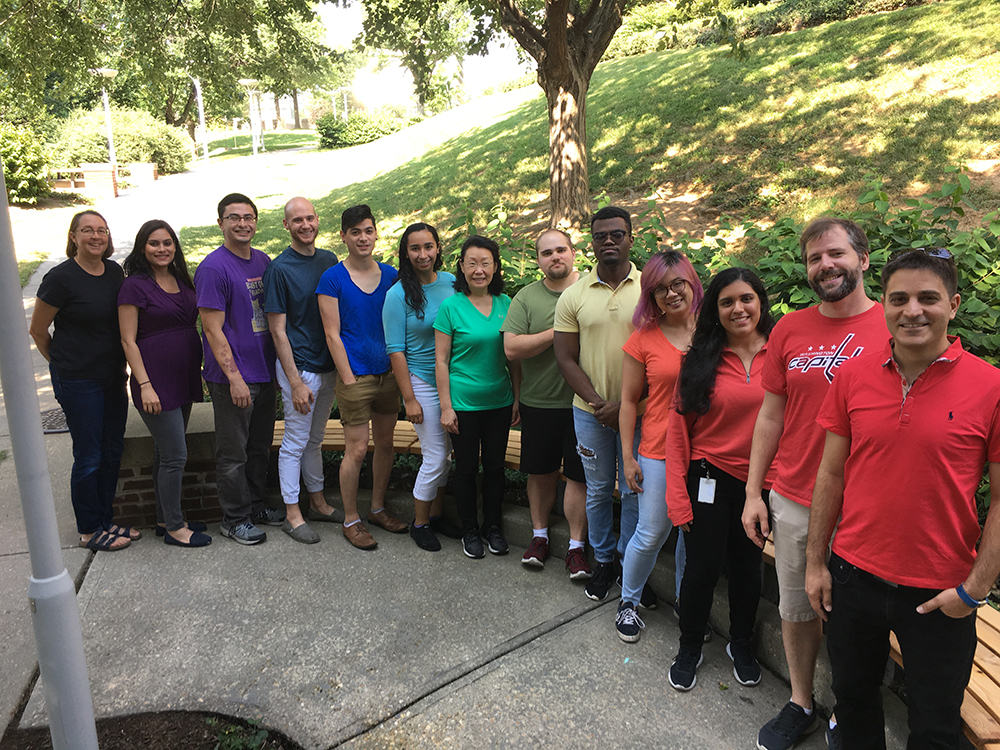 Members of the Storz lab wearing shirts in colors of the rainbow from violet to red.