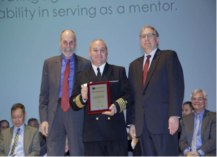 Dr. Yanovski standing with award.