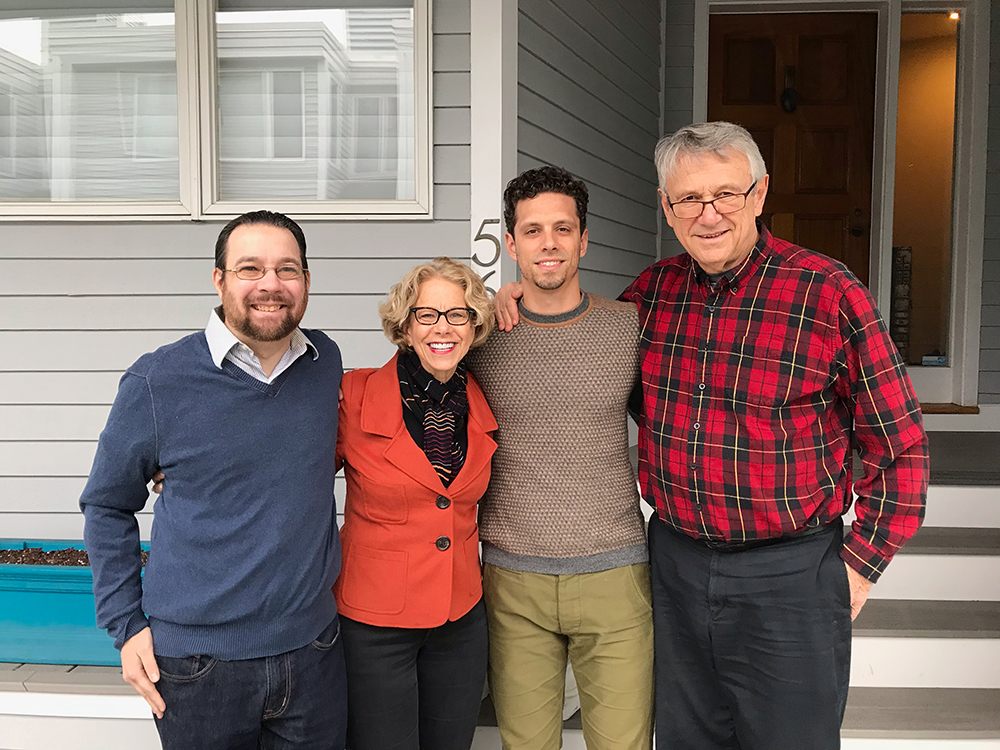 Dr. Bianchi and her family are standing outside, arm-in-arm, and smiling. 