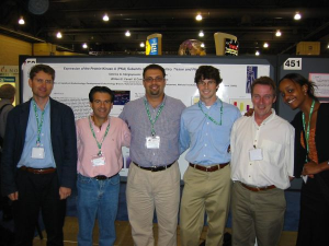 6 people standing in front of poster.