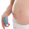 Pregnant woman holding asthma inhaler.