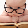 baby in glasses on top of book