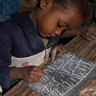small child writing on small chalkboard