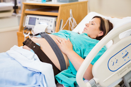 Pregnant woman in hospital bed.