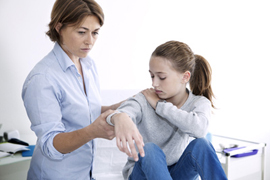 Nurse examining the arm of a teenage girl
