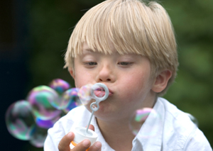 Boy with Down Syndrome blowing bubbles