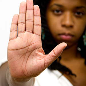 Young adult with stop gesture hand sign
