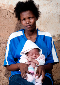 Young African mother holding her baby on her lap