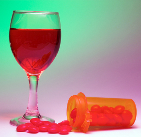 Glass of wine and a bottle of pills