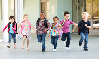 Group of elementary age schoolchildren running outside