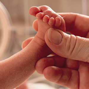 Adult holding up newborn's foot.