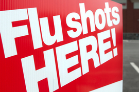 A sign advertises flu vaccines, with the words 'Flu Shots HERE!'