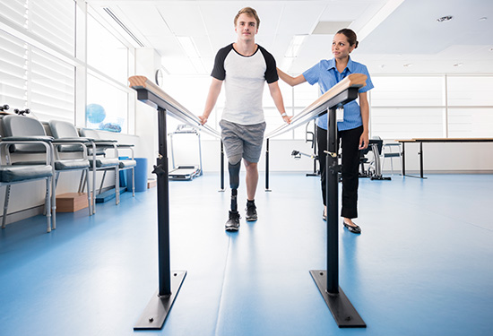 Stock image of man with prosthetic leg undergoing physical therapy